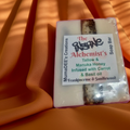 Soap bar with a label on an orange fabric background
